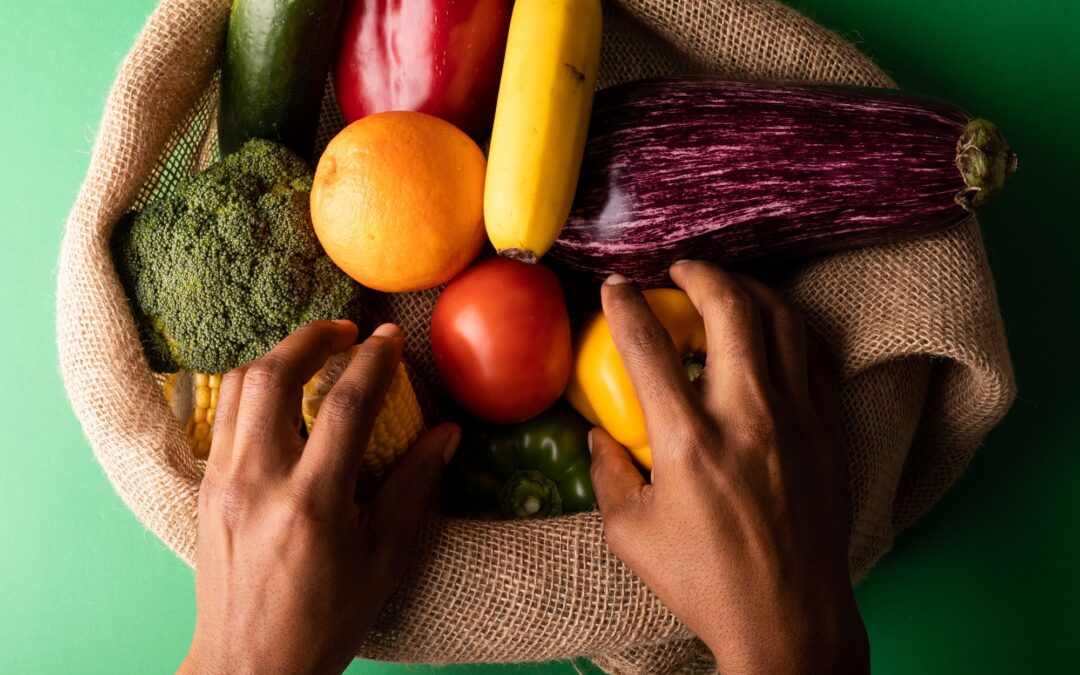 Cropped hands of mixed race man picking up vegetables from burlap sack